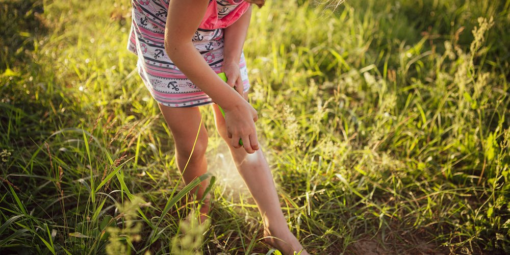 girl spraying repellent mosquito control